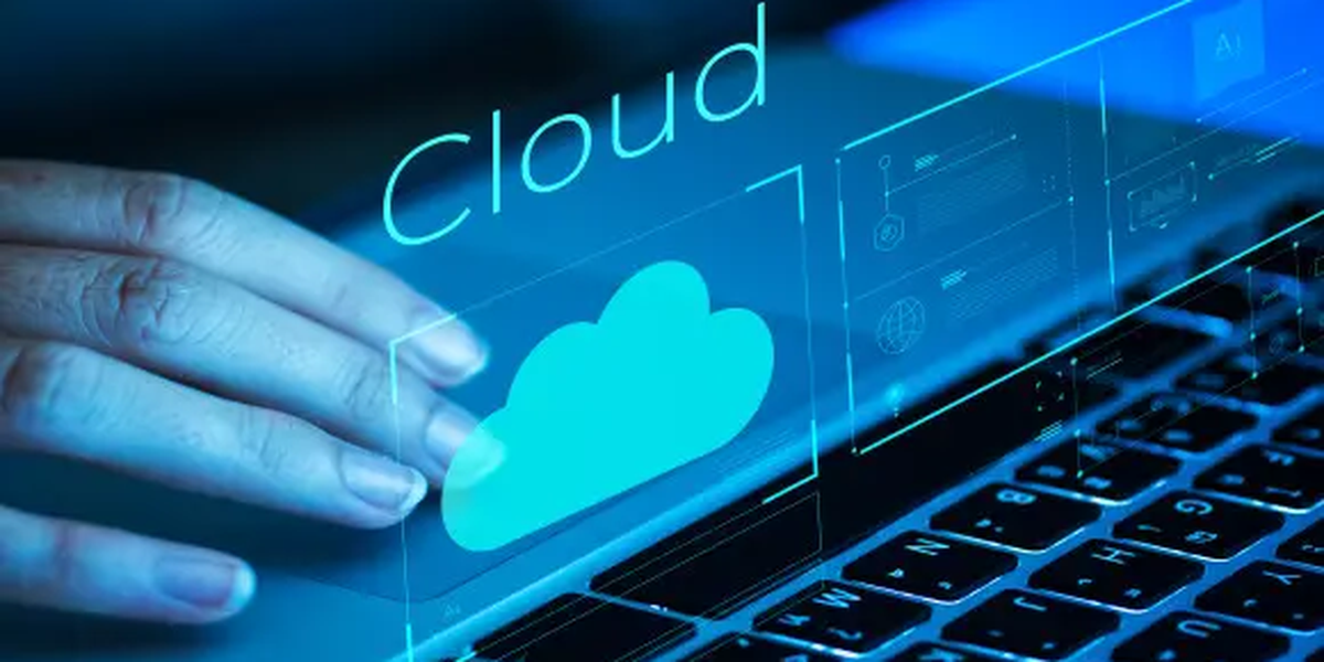 Hand on a laptop keyboard with a glowing cloud computing icon, representing Oracle Cloud migration